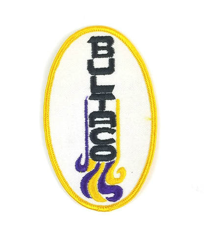Embroidered 5" oval "BULTACO" Spanish motorcycle sew-on patch in cream with black, purple and yellow stitching.