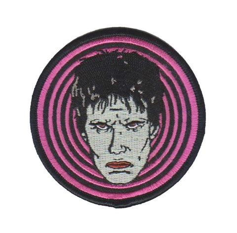 3" round embroidered patch of Lux Interior's glamour ghoul face against hot pink & black concentric circle background