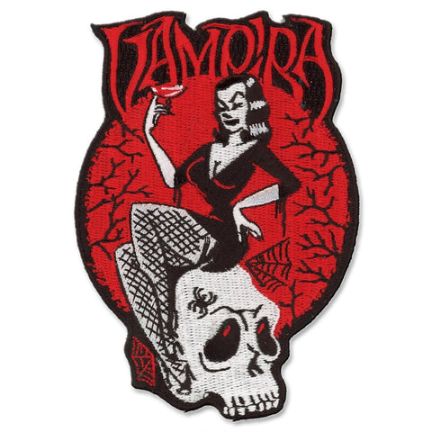 50s horror hostess Vampira sitting on skull illustrated in bold black, white and red on a 3.5" x 5" embroidered patch