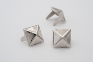 three 3/8" (9.5mm) silver metal pyramid studs, shown at different angles