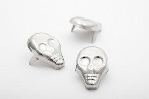 three 5/16" x 11/16" x 1/8" silver metal skull shaped studs