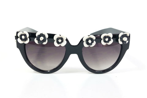shiny black plastic frame sunglasses with applied hand-molded black & white flower trim at brow and arms and gradient smoke lens
