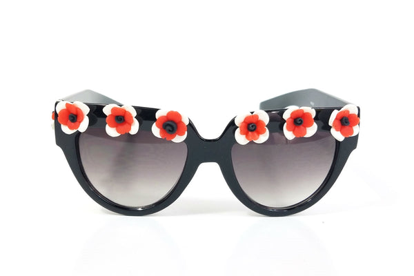 shiny black plastic frame sunglasses with applied hand-molded red & white flower trim at brow and arms and gradient smoke lens