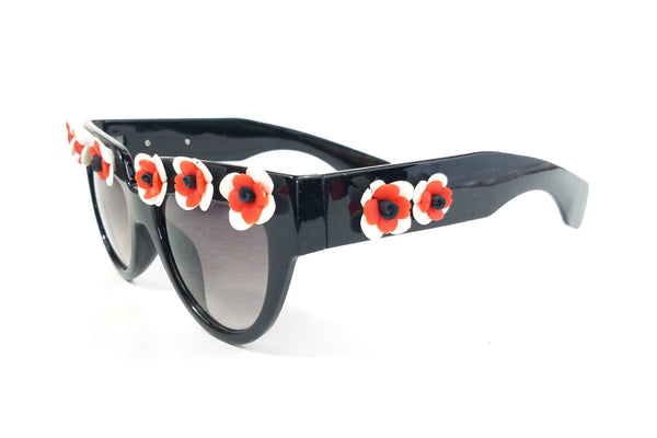 shiny black plastic frame sunglasses with applied hand-molded red & white flower trim at brow and arms and gradient smoke lens