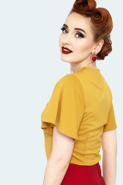 A model wearing a mustard colored knit top with flutter style short sleeves and a keyhole detail neckline. Shown from the side