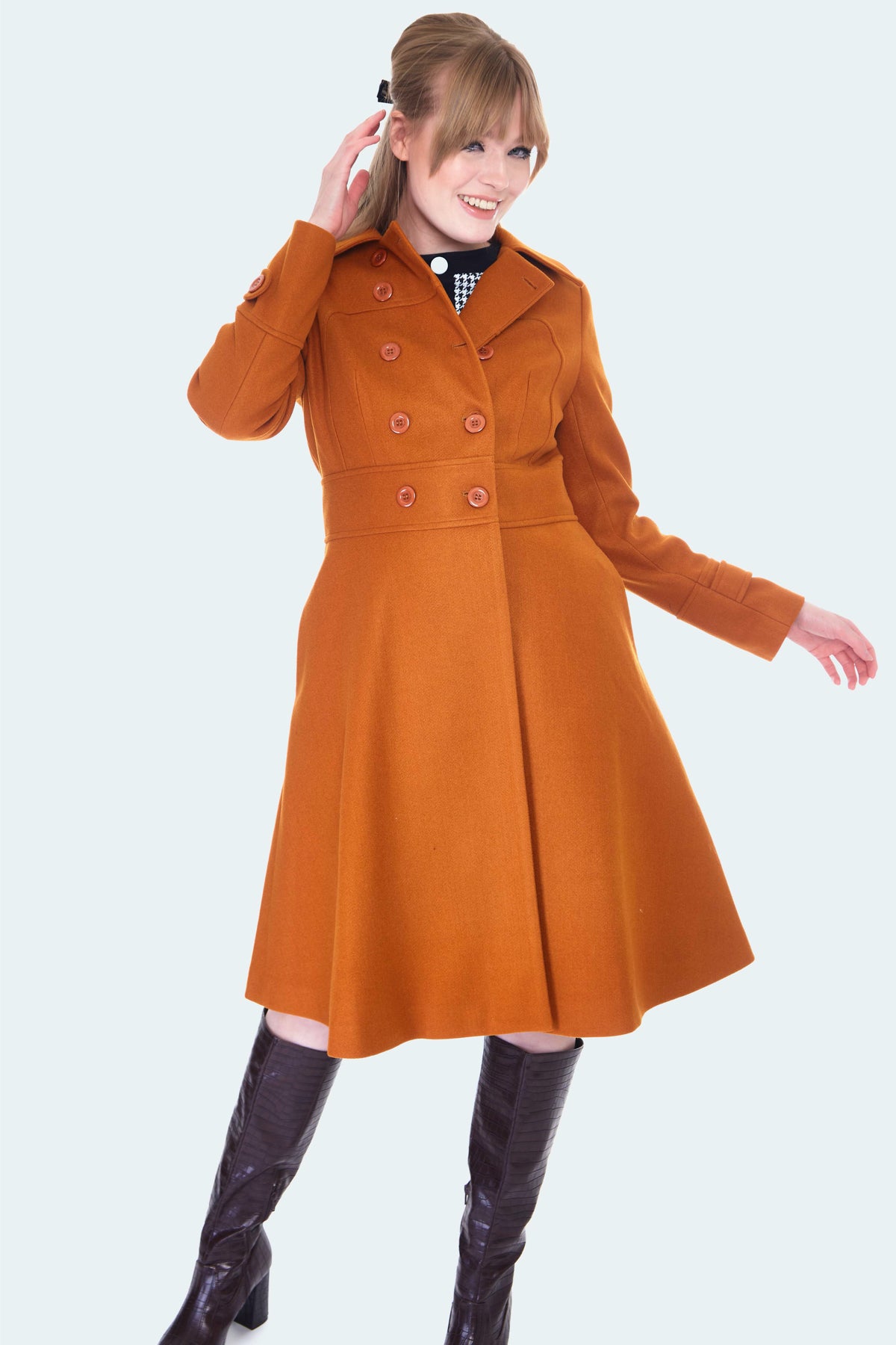 Burnt orange wool double breasted coat with fit and flare silhouette and pockets. Hits at knee. Shown on model