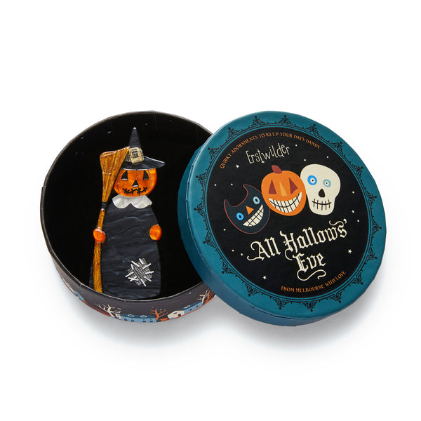 All Hallows' Eve collection "The Stitched Witch" black and orange pumpkin-headed witch holding broom layered resin brooch, shown in illustrated round box packaging