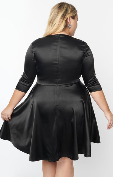 shiny stretch black satin dress featuring a Trompe l'oeil "painted on" scarf and collar printed in contrast bright white, fitted round neckline bodice, 3/4 sleeves, and full just-above-the-knee length skirt, shown back view on model