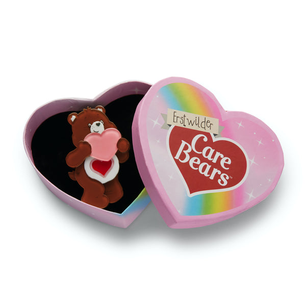 Care Bears Collection "A Tender Heart" brown bear holding pink heart layered resin brooch, shown in illustrated heart-shaped box packaging
