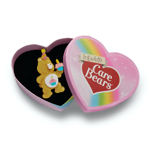 Care Bears Collection "Birthday Bear's Cake" bear in party hat holding cupcake layered resin brooch, shown in illustrated heart-shaped box packaging