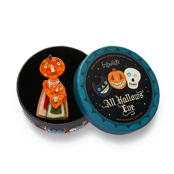 All Hallows' Eve collection "The Pumpkin Family Affair" orange, cream, burgundy, and green pumpkin-headed mother and child layered resin brooch, shown in illustrated round box packaging