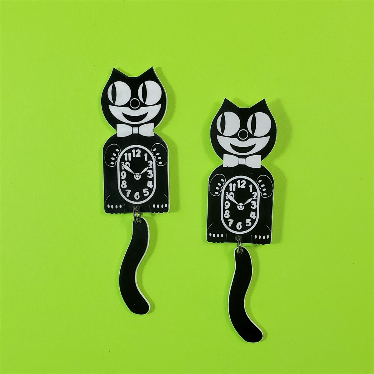 pair Cat Clock black & white layered acrylic post earrings with attached swinging tails